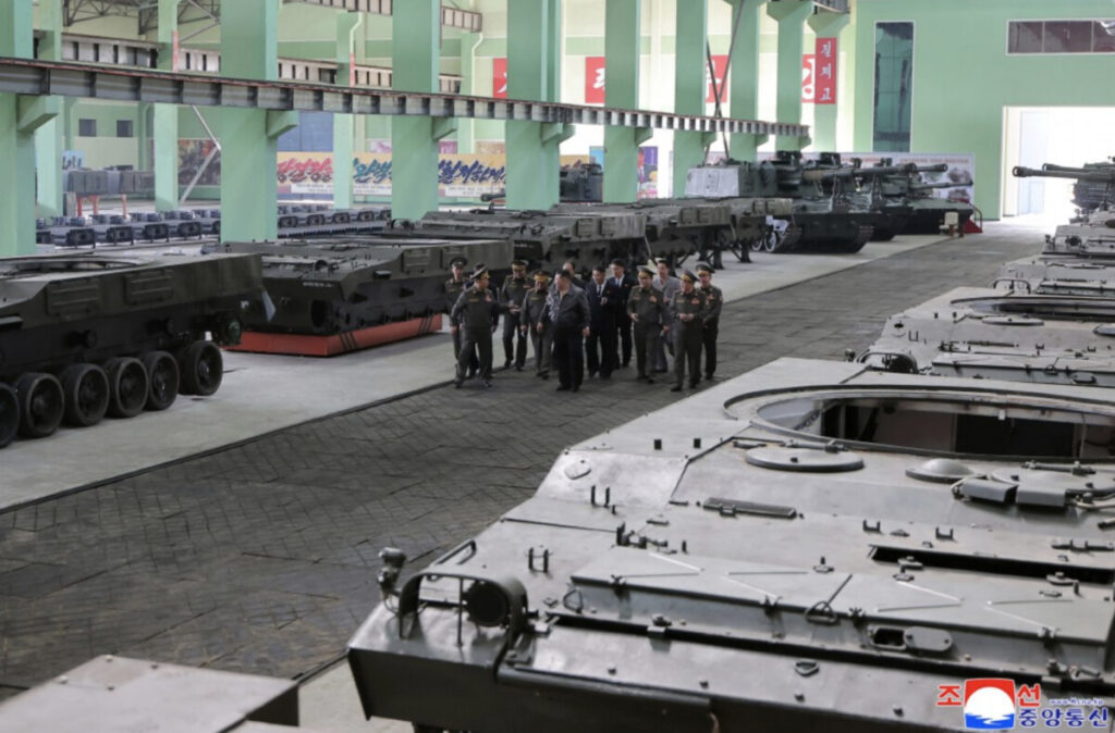 Screenshot 20260510 at 2 54 02 pm | nk insider group of military officers in uniform standing together among a line of tanks inside a large green hangar